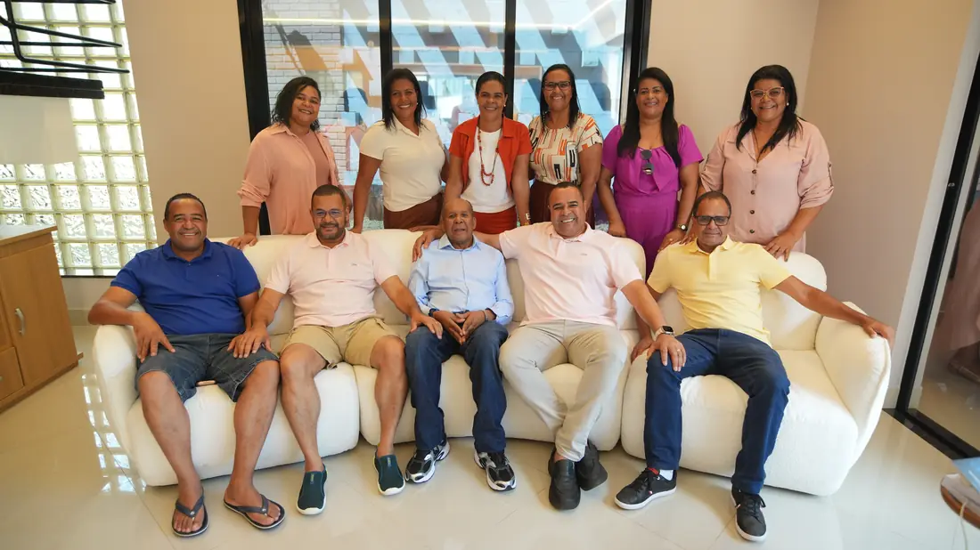 Família reunida em uma sala clara, posando para retrato